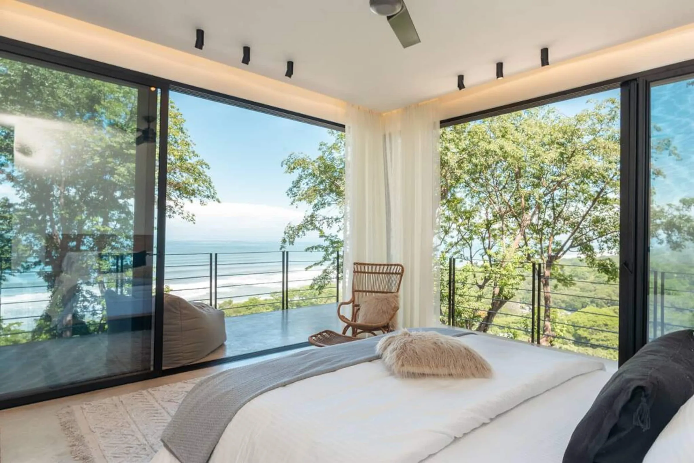 Bedroom with floor-to-ceiling windows and an ocean view