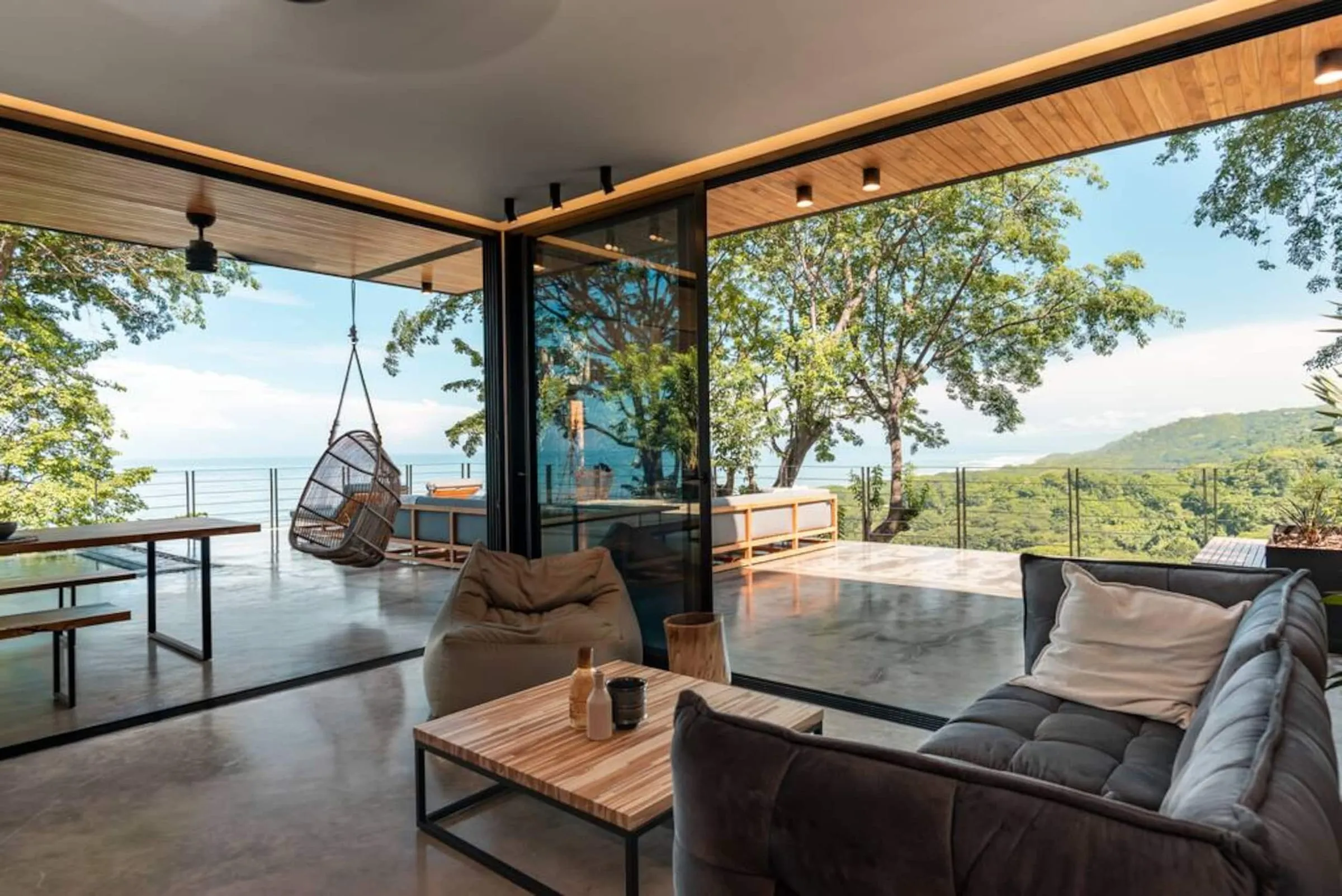 Open living room with glass walls onto the jungle
