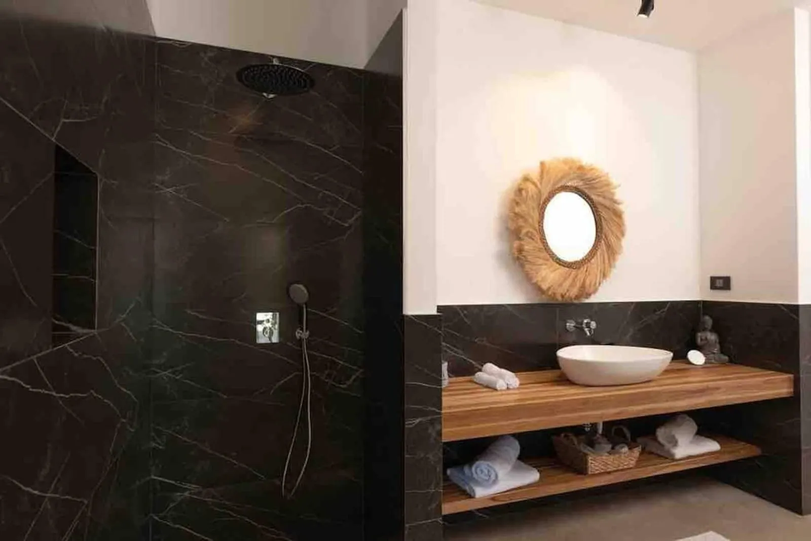 Dark stone bathroom with a round mirror